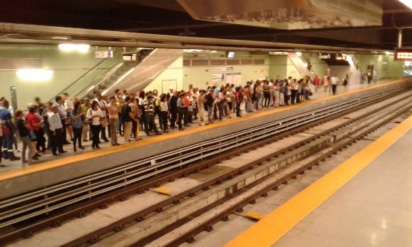 sittycia | OPORTUNIDADES DE NEGOCIO EN PANAMÁ Multitud de pasajeros esperando en un andén del metro con dos vías vacías visibles y líneas de seguridad amarillas en el borde del andén.