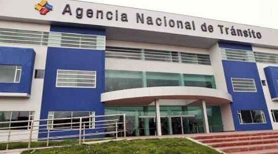 Vista frontal del edificio de la agencia nacional de tránsito, de diseño moderno con fachada azul y blanca y grandes ventanales de vidrio.
