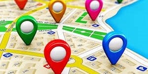 Un mapa digital que muestra múltiples marcadores de ubicación coloridos en calles cercanas a una masa de agua azul. Un mapa digital que muestra múltiples marcadores de ubicación coloridos en calles cercanas a una masa de agua azul.