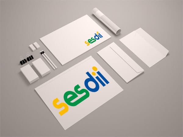Mercadeo Set de papelería que incluye tarjetas de visita, carpetas y blocs de notas con el logo "sesdii" en verde y amarillo sobre fondo gris para fines de marketing.