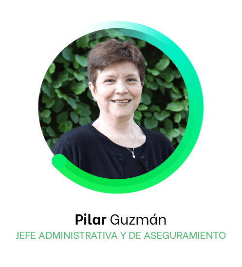 Una mujer llamada Pilar Guzmán, Jefa Administrativa y de Aseguramiento, sonríe frente a un fondo verde exuberante, encarnando la esencia de Líderes que se conectan perfectamente con su entorno.