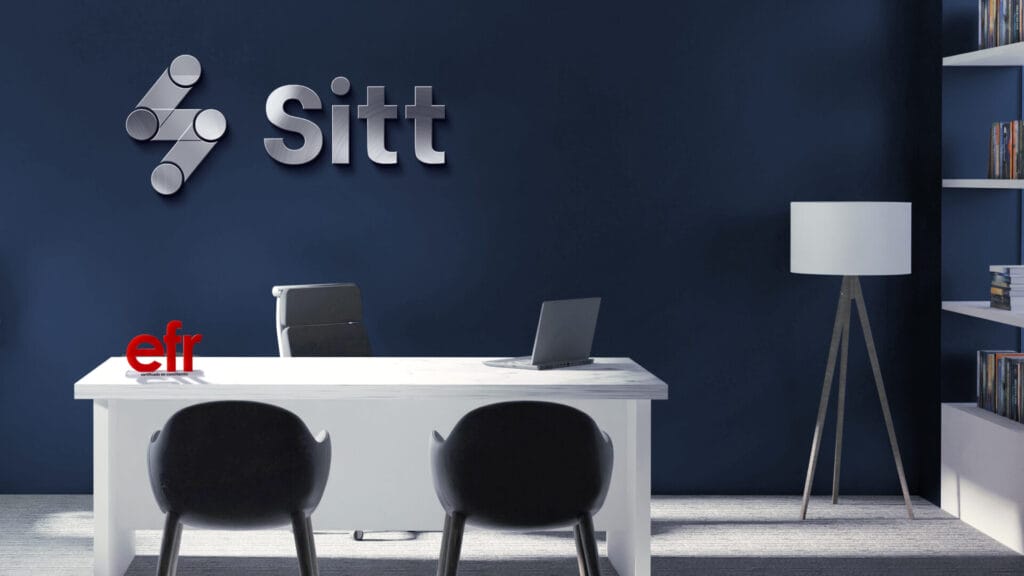 Espacio de oficina moderno con un escritorio blanco, dos sillas negras, una computadora portátil, una lámpara y estanterías. La palabra «Sitt» está colgada en una pared azul oscuro detrás del escritorio. Un letrero rojo con la palabra «efr» está sobre el escritorio. Espacio de oficina moderno con un escritorio blanco, dos sillas negras, una computadora portátil, una lámpara y estanterías. La palabra "Sitt" está colgada en una pared azul oscuro detrás del escritorio. Un letrero rojo con la palabra "efr" está sobre el escritorio.